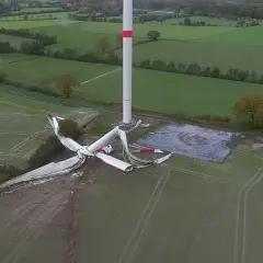 Ein Windrad Unfall hat die Rotorblätter zerfetzt. Trümmer liegen verstreut auf dem Feld neben dem intakten Turm.