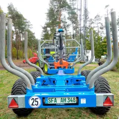 Ein blauer Rückewagen mit dem Kennzeichen SFA AH 348, bereit für den Einsatz im Wald. Dieses Folgekennzeichen landwirtschaft zeigt, dass er für den Transport von Holz bestimmt ist.
