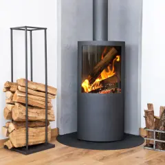 Moderner Kamin mit brennendem Holz. Ein Stapel Holz daneben. Diskussionen über ein holzheizung verbot sind angesichts dieser gemütlichen Szene unwahrscheinlich.