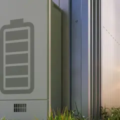 Ein moderner Batteriespeicher steht im Freien. Das Symbol einer vollen Batterie ist auf der Seite angebracht, was auf einen erfolgreichen batteriespeicher test hindeutet.