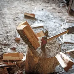 Axt spaltet Holzscheit. Informiere dich über aktuelle brennholz preise bayern, um dein Zuhause warm zu halten.
