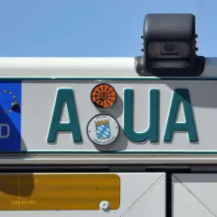 Kennzeichen "AQUA 1" auf einem Traktor. Das schwarze Kennzeichen hat ein EU-Feld und das Stadtwappen von Augsburg.