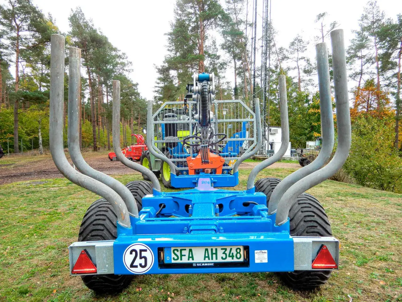 Ein blauer Rückewagen mit dem Kennzeichen SFA AH 348, bereit für den Einsatz im Wald. Dieses Folgekennzeichen landwirtschaft zeigt, dass er für den Transport von Holz bestimmt ist.