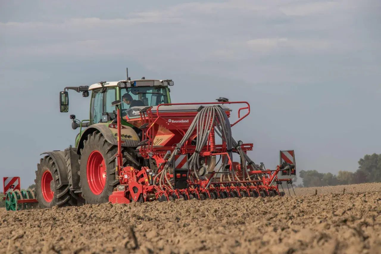Traktor mit Sämaschine bei der Sommergerste Aussaat auf einem Feld.
