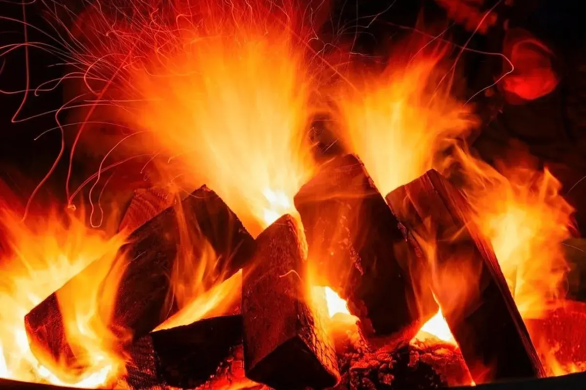 Flammen tanzen um Holzscheite, die zu einem knisternden Feuer werden. Ob buche hart oder weichholz, die Glut verspricht Wärme.