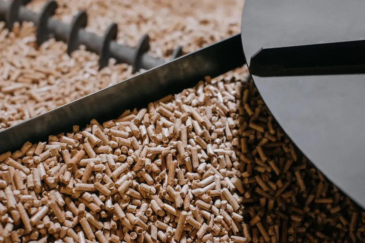 Holzpellets, ein wichtiger Bestandteil der erneuerbaren Energie, werden von einer Förderschnecke transportiert.