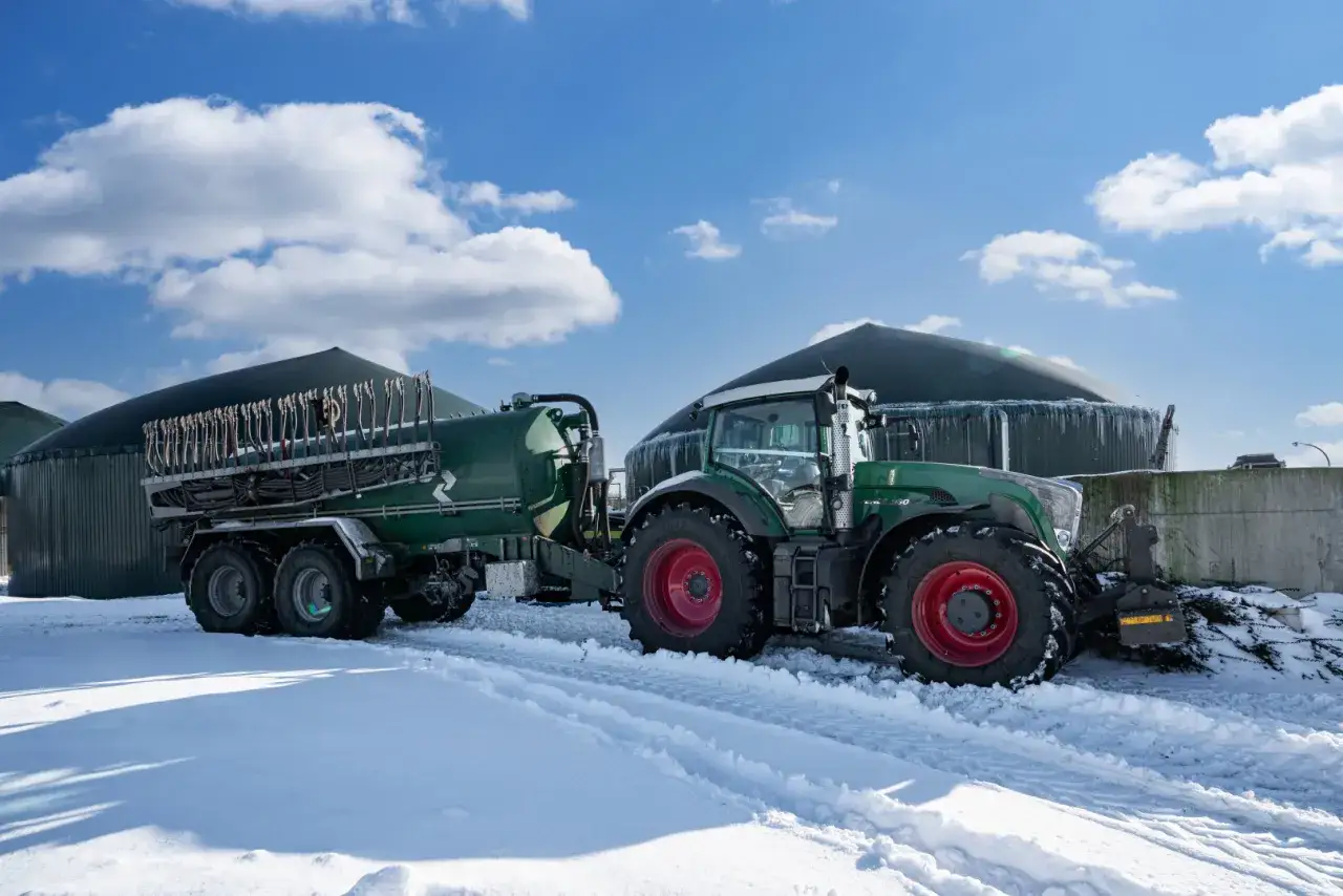 Traktor mit G&uuml;llefass im Schnee vor Biogasanlagen. Der Kalkstickstoff Verbot k&ouml;nnte Auswirkungen auf solche Anlagen haben.