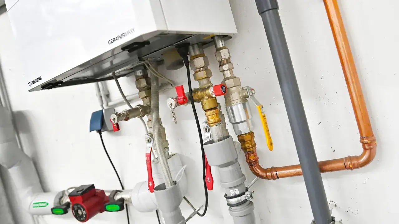 Nahaufnahme einer Junkers CERAPURMAXX Heizung mit Rohren und Ventilen. Informieren Sie sich über die Biogas Heizung Kosten.
