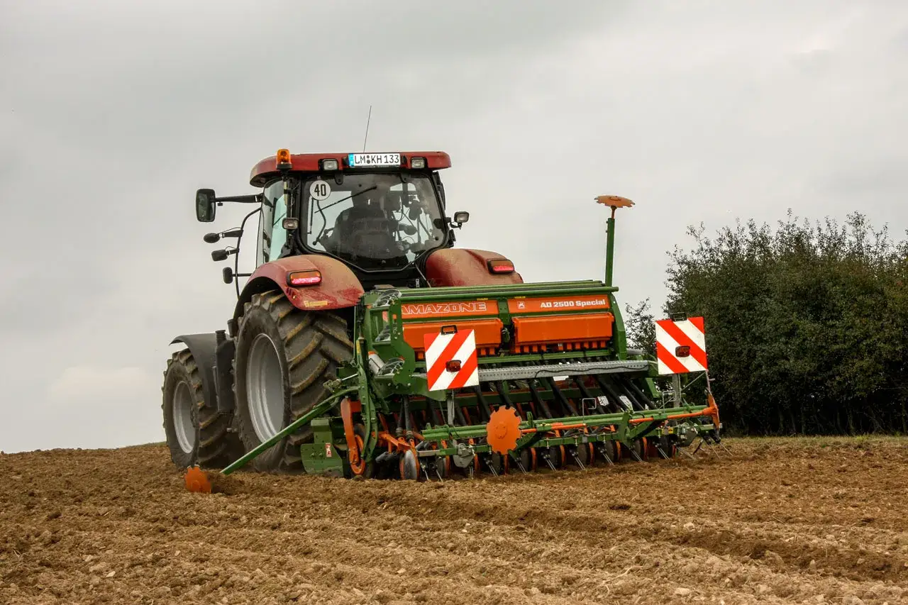 Traktor mit Amazone Sämaschine für die Roggen Aussaat auf einem Feld.